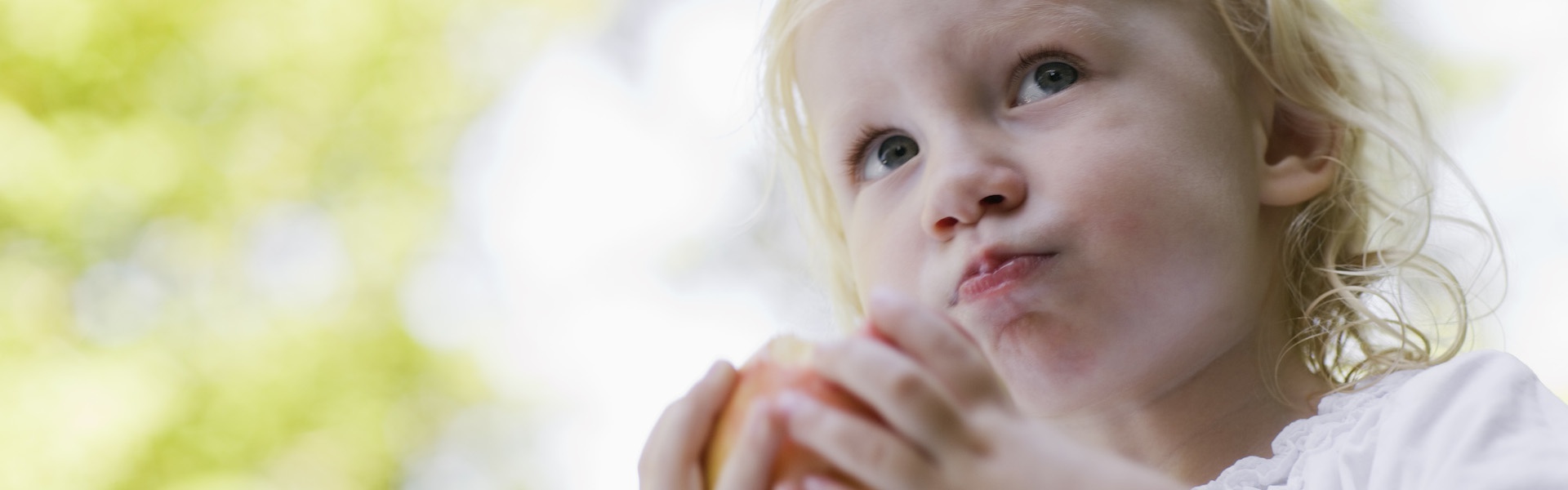 Ein Mädchen isst einen Apfel (Foto)